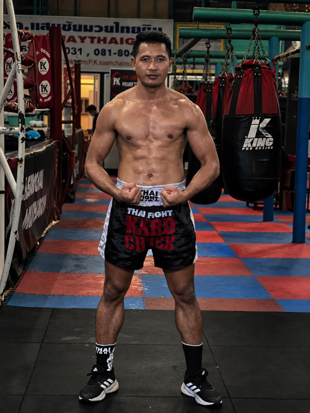 A fighter standing on the mats inside P.K. Saenchai Muay Thai Gym