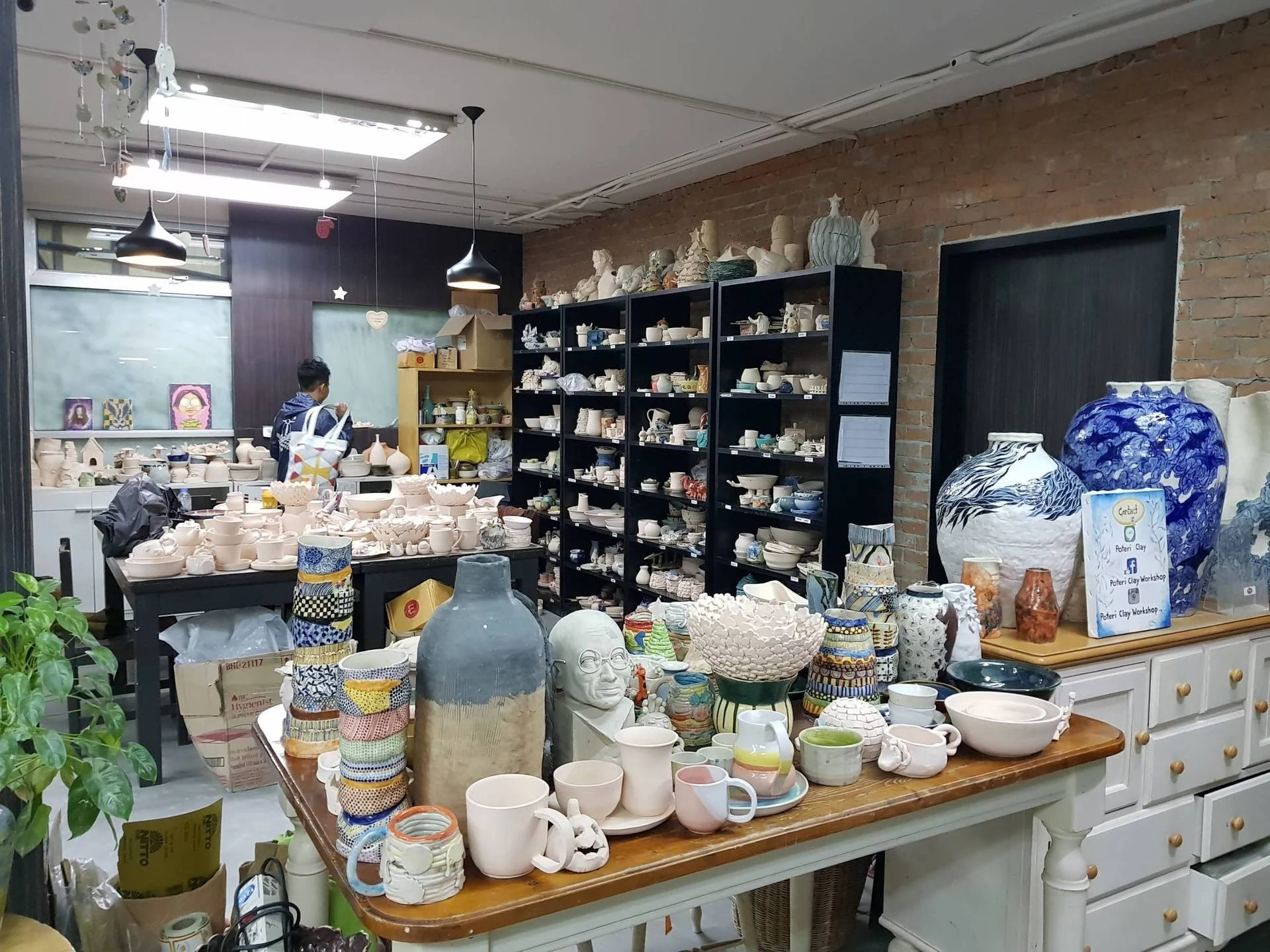 Hands shaping clay at a pottery workshop