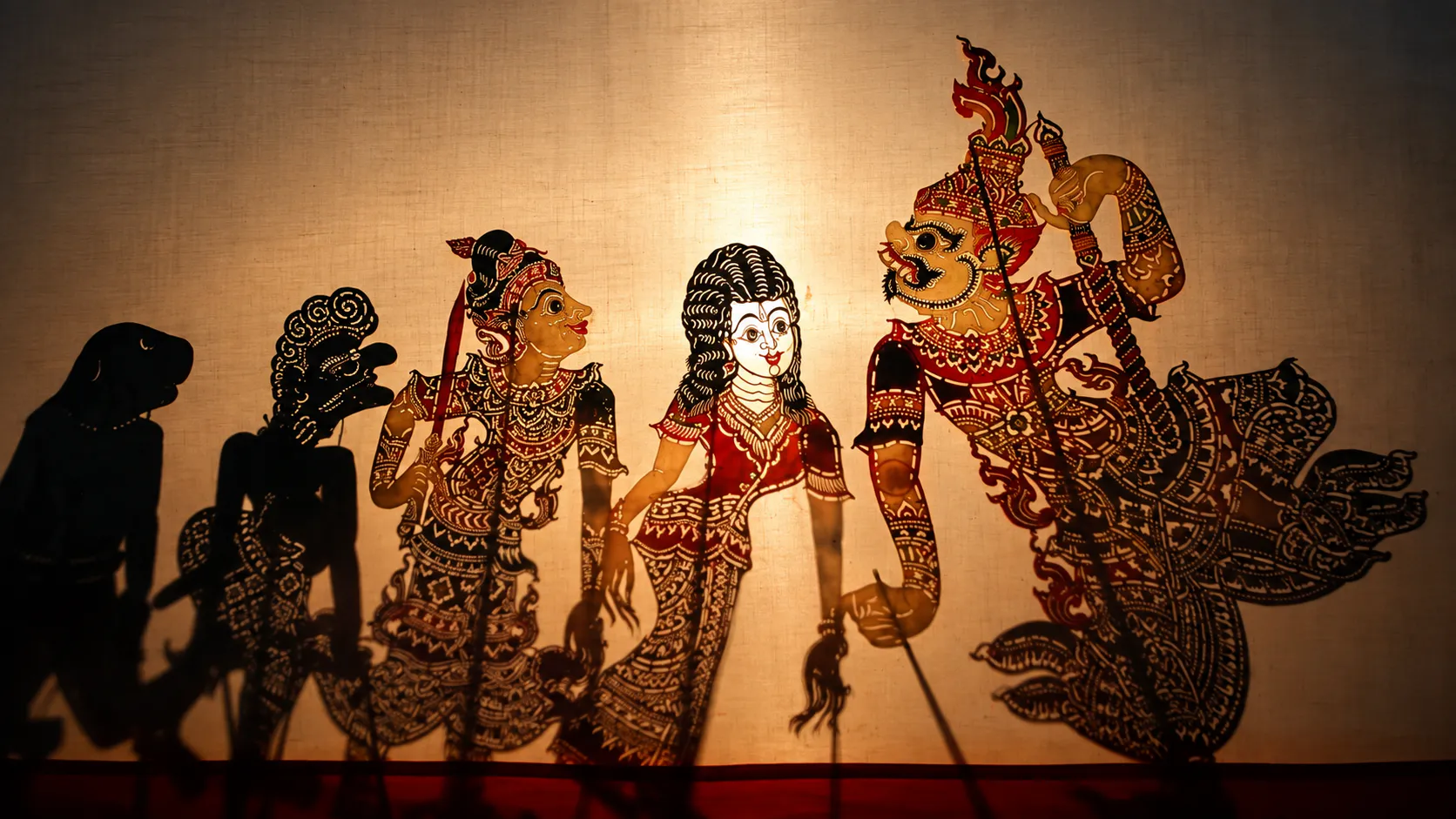 Nang Talung shadow puppets illuminated on a traditional southern Thai screen