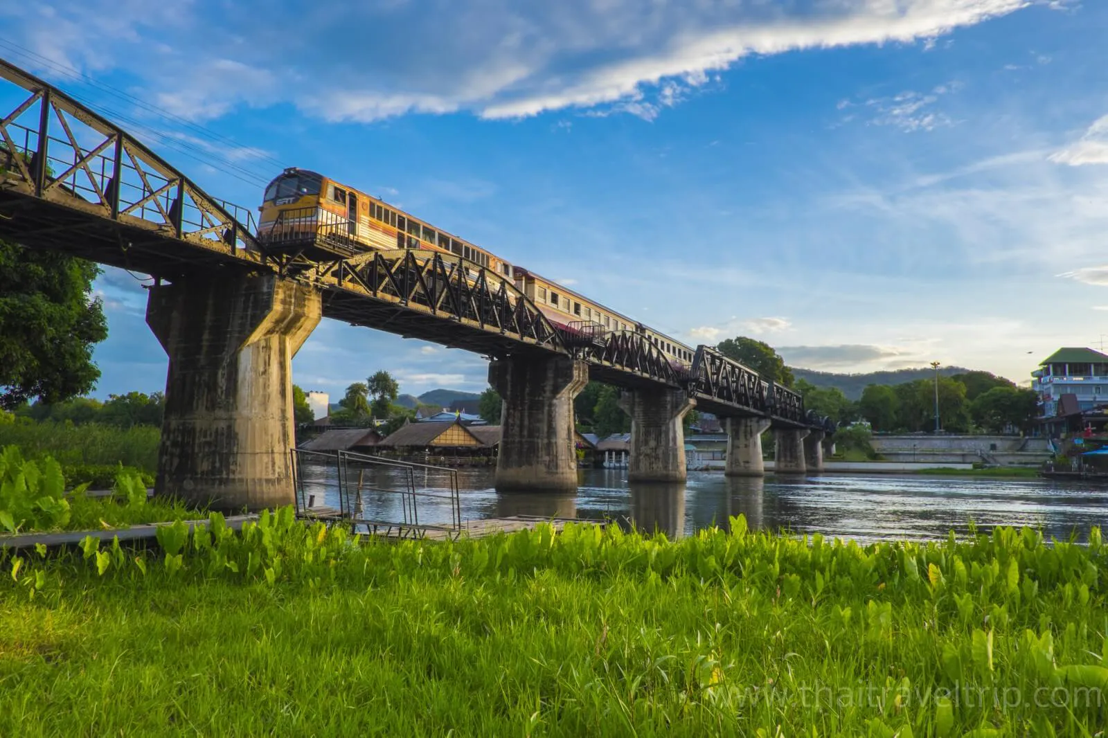 Historic Bridge over the River Kwai with a train crossing in Kanchanaburi